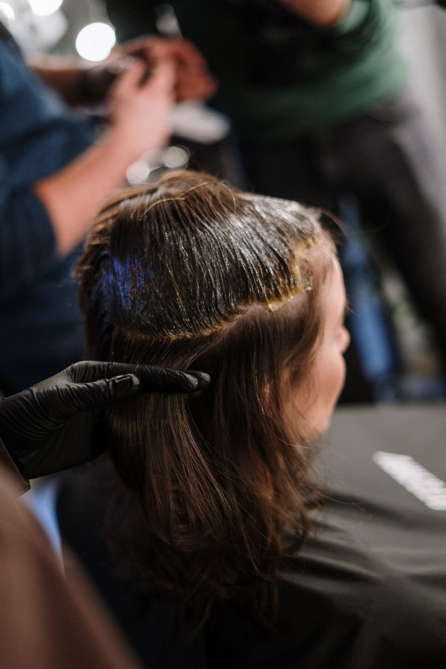 Colourist applying hair colour to a client in the salon